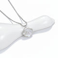 Shell-shaped pendant on a chain against a light gray background