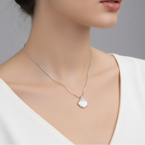 Shell-shaped pendant on a chain against a light gray background